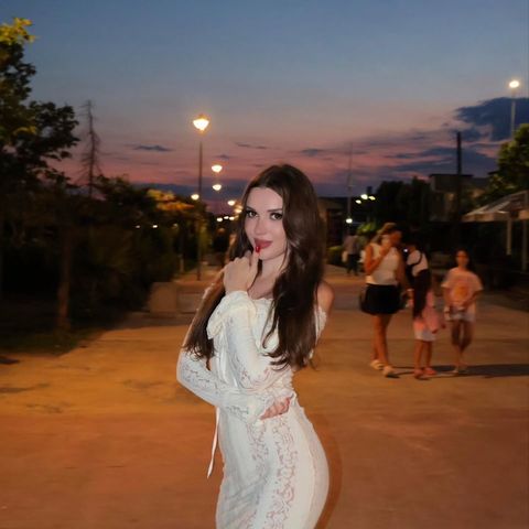 Viki Angels, alacakaranlıkta, sokak lambaları yanmışken toprak bir yolda beyaz dantel bir elbiseyle
